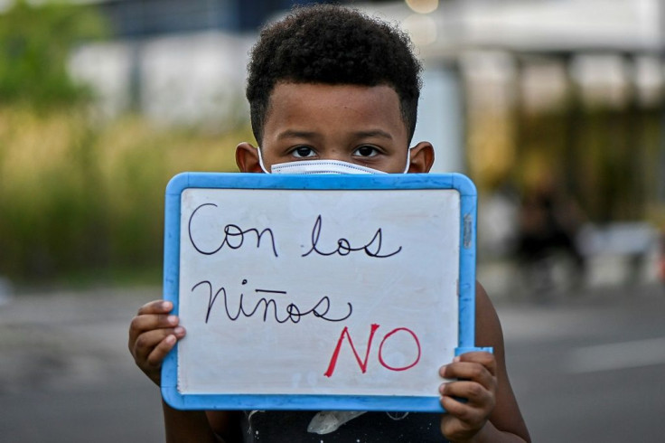 A child holds a sign during a protest in Panama City on March 3, 2021 to demand jail for those allegedly involved in cases of abuse of minors at orphanages