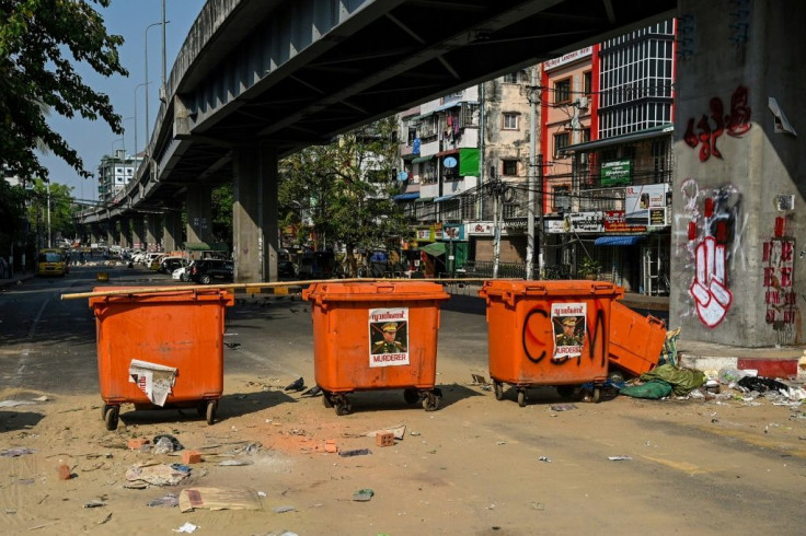 Bins with images of Myanmar armed forces chief Senior General Min Aung Hlaing are set up by protesters as makeshift barricades to block the road