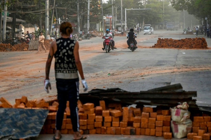 A protester stands in front of a makeshift barricade constructed out of bricks during demonstrations against the coup in Yangon on March 9, 2021