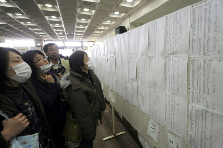 People check lists for survivors at an evacuation centre in Miyagi prefecture on March 14, 2011