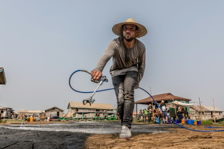 A white man is a rare sight in Ganvie village, let alone one creating a huge painting on the ground