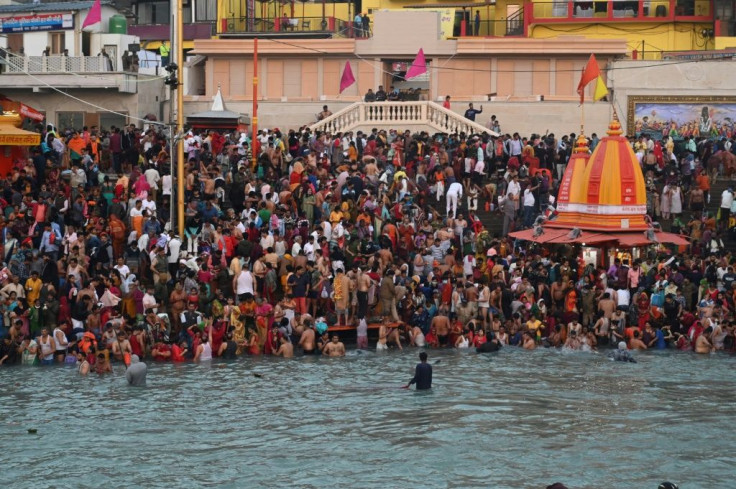 Pilgrims jostled for space along the Ganges before taking a brief plunge in the fast-flowing water and sung hymns and showered flowers into the holy river