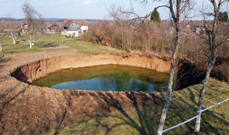The sudden depressions are caused by ground water eroding the bedrock below the soil