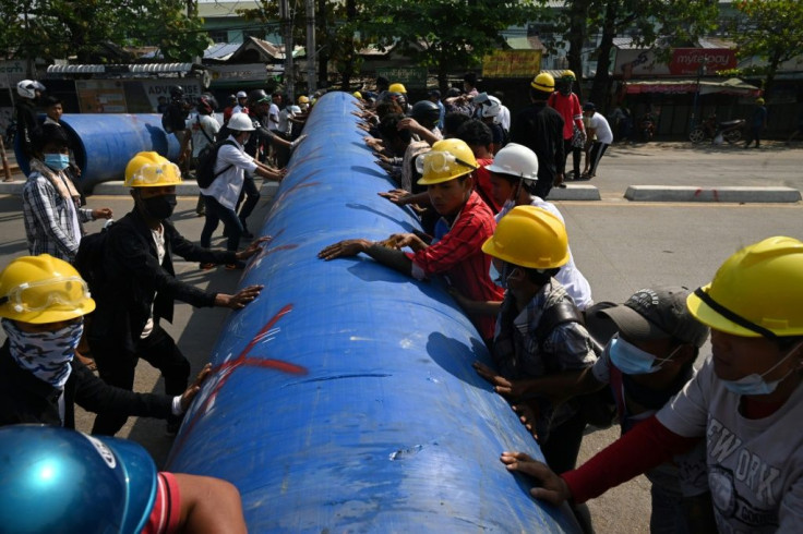 Anti-coup protesters in Myanmar rolled a large pipe into a Yangon street to build a barricade
