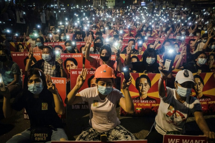 Protesters hold up the three-finger salute and images of detained Myanmar civilian leader Aung San Suu Kyi during a demonstration against the military coup in Yangon