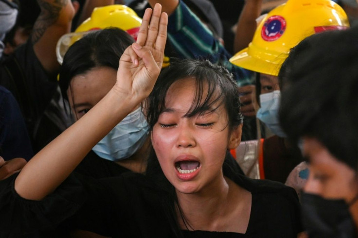 The sister of Chit Min Thu, who died during an anti-coup demonstration on March 11, cries as she makes the three-finger salute during her brother's funeral in Yangon