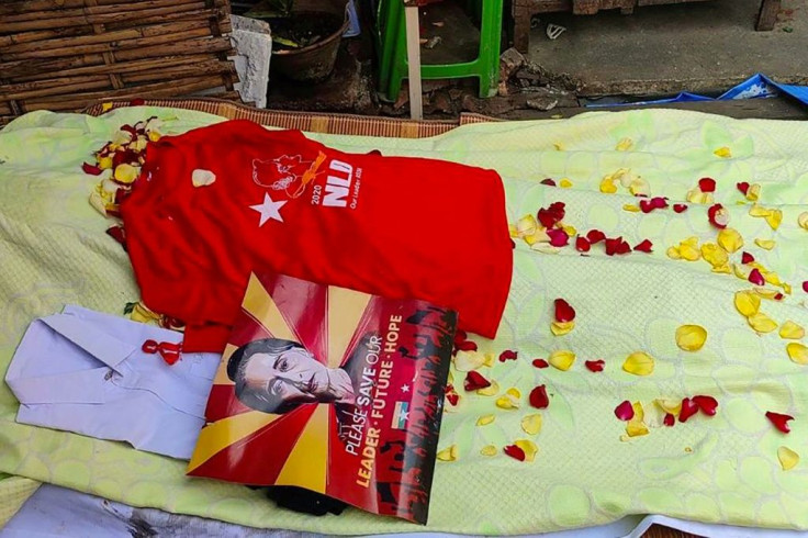 A poster of detained civilian leader Aung San Suu Kyi and a T-shirt supporting her NLD party are placed on the covered body of Si Thu, an NLD supporter killed overnight in Thaketa township in Yangon