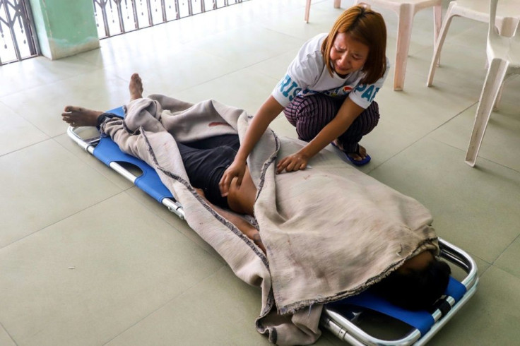 The sister of Saw Pyae Naing, who was killed during a demonstration on Saturday, grieves over his body at a makeshift medical centre in Mandalay