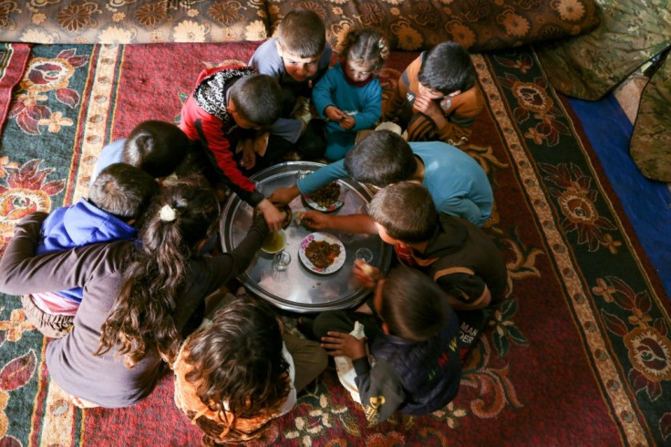 The children share a simple meal of flatbread, hummus, olives and dried thyme drenched in olive oil