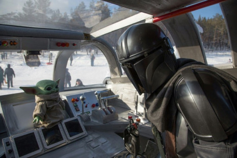 A man wearing a costume of the StarWars protagonist Din Djarin poses onboard a giant replica of the Razor Crest, a gunship from the StarWars spinoff series "The Mandalorian" in the city of Yakutsk