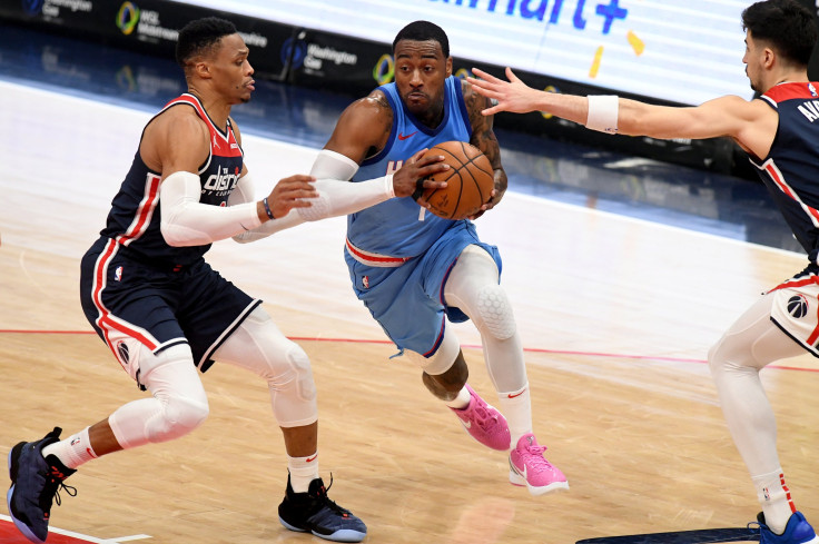 John Wall #1 of the Houston Rockets dribbles in front of Russell Westbrook #4 of the Washington Wizards 