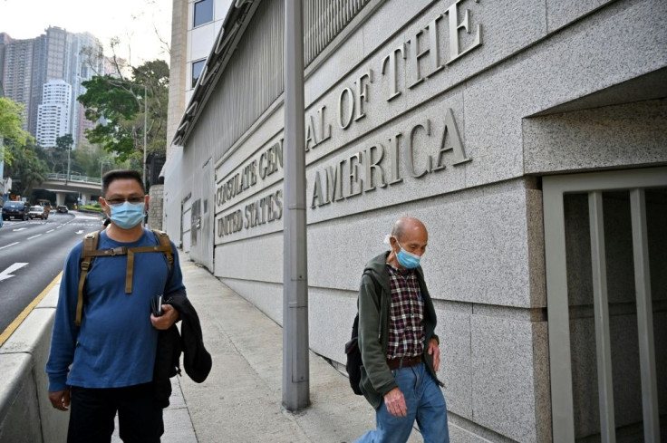 People walk past the US consulate building in Hong Kong following its temporary closure