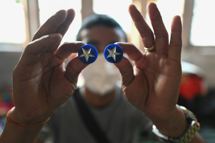 A Myanmar policeman, who fled illegally to India, shows his uniform rank badges. More than 300 Myanmarese -- many of them police officers and their families -- have crossed into northeast India's Mizoram state since the military coup