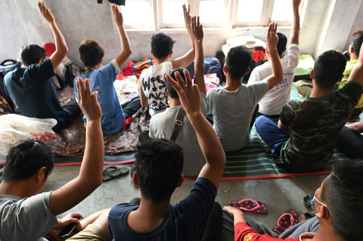 Policemen who fled Myanmar hold up the three-finger salute inspired by the 'Hunger Games' films and adopted by protesters