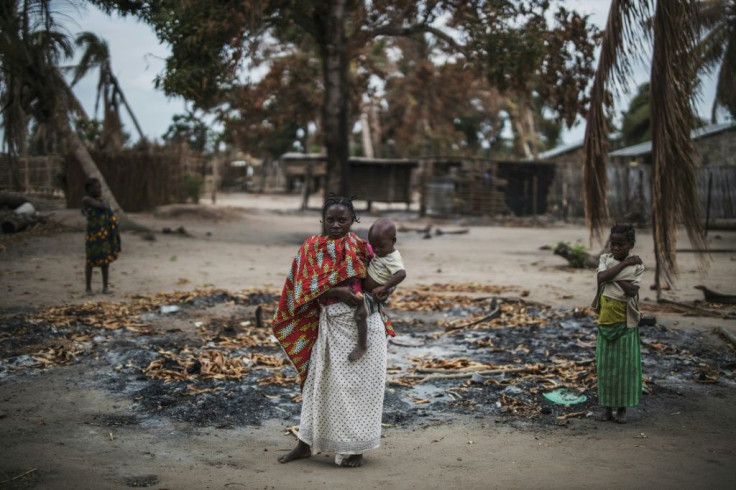 A woman and her child in the remains of a home in Aldeia da Paz, a village in Cabo Delgado province that was attacked in August 2019