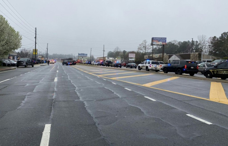 Law enforcement cars block the area of a shooting at a spa in an Atlanta suburb