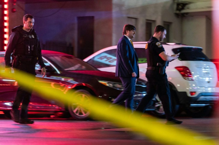 Law enforcement personnel leave a massage parlor where a person was shot and killed on March 16, 2021, in Atlanta, Georgia