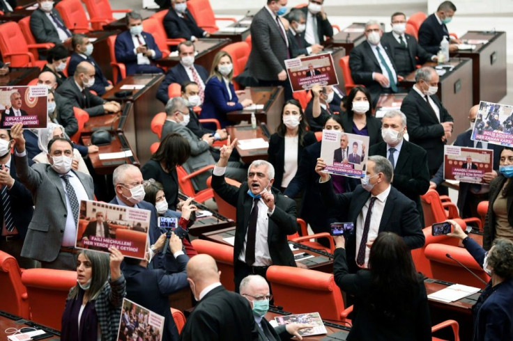 Turkish member of parliament Omer Faruk Gergerlioglu reacts with other MPs after his dismissal