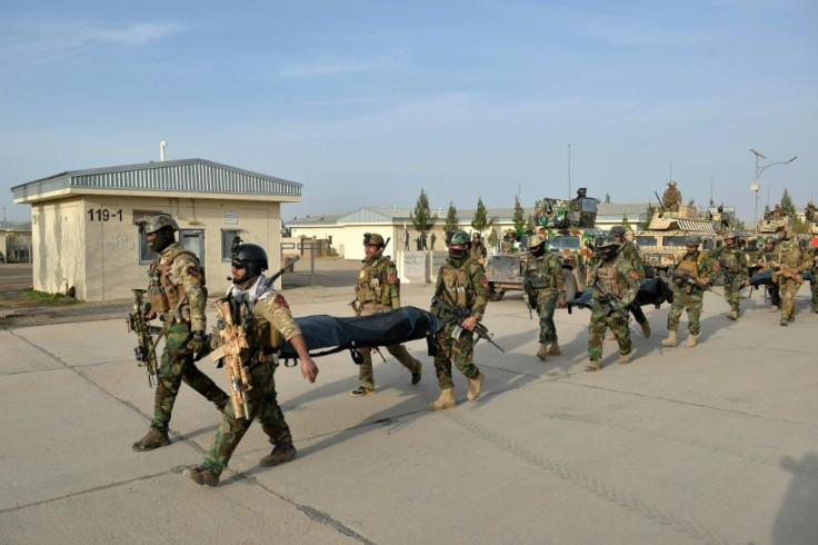 Afghan National Army (ANA) commandos carry the dead bodies of Taliban fighters after a military operation in the Guzra district of Herat province on March 16, 2021