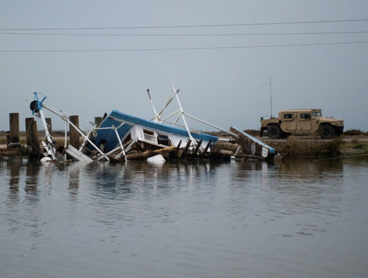A truck with the US National Guard drives past a destroyed shrimping boat after the passing of hurricane Laura in Hackberry, Louisiana on August 28, 2020