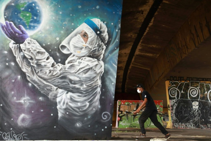 A man skates past coronavirus-related graffiti in Sapucaia do Sul, Rio Grande do Sul state, Brazil; Brazil's central bank has raised its interest rate as the country's health system -- and economy -- reeled from the latest surge in Covid-19