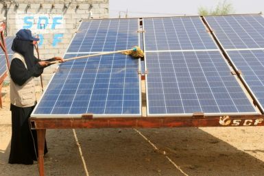 A Yemeni woman cleans a solar panel at the Friends of the Environment Station