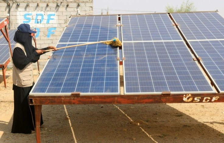 A Yemeni woman cleans a solar panel at the Friends of the Environment Station