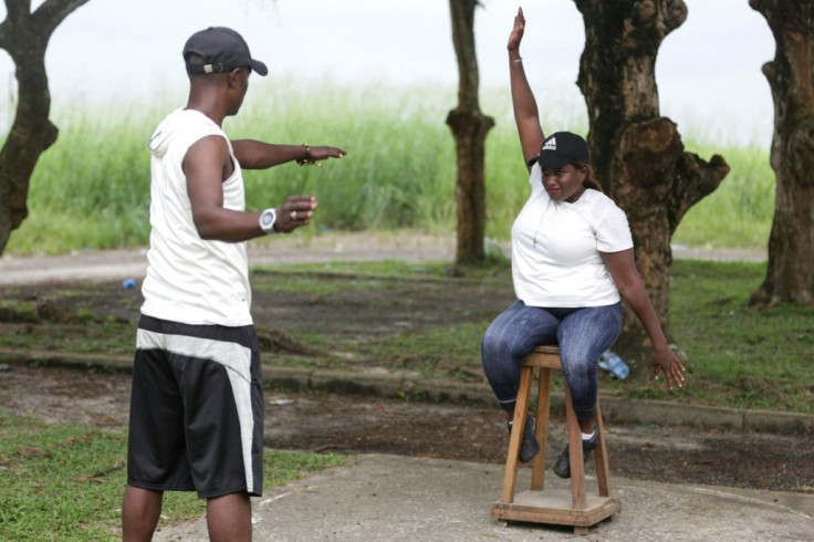 Paralympic athlete Audray Fabiola Mengue Pambo uses a wooden stool to warm up for the shot put
