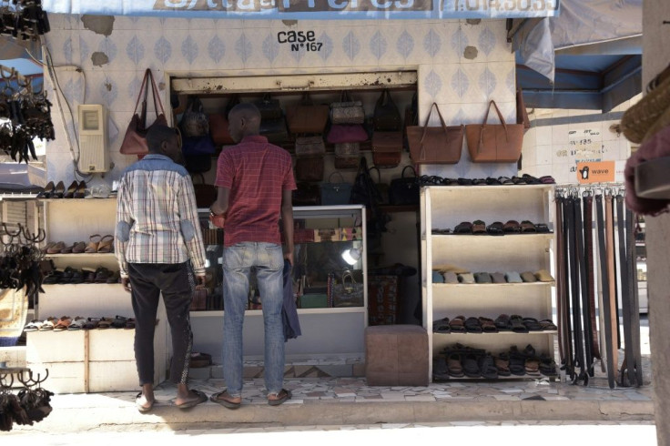 Workers chat at the market stalls -- many come in, at cost, in the hope of snaring the occasional customer