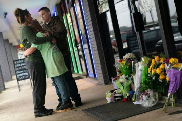 People hug outside Youngs Asian Massage where four people were shot and killed in Acworth, Georgia