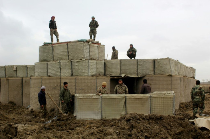 Afghan security forces stand guard at an army post after a Taliban attack