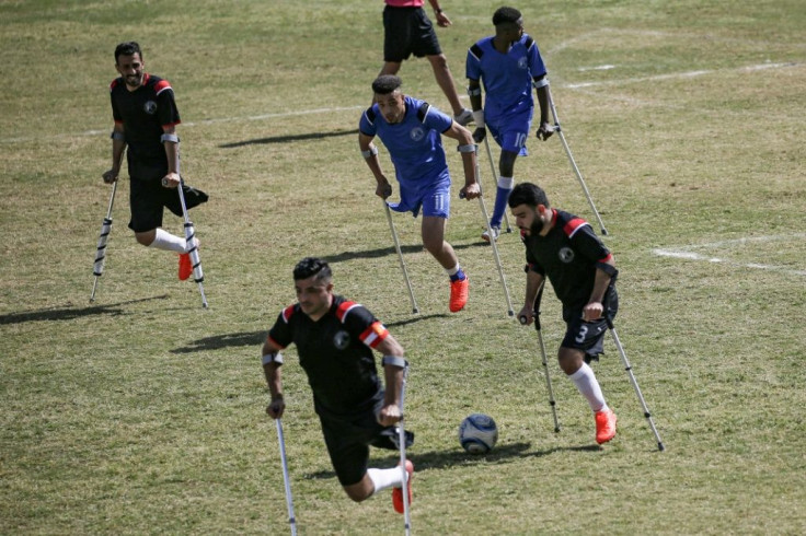 Palestinian footballers compete in the final of a local championship for amputees between Al-Jazeera (black kit) and Al-Abtal (blue kit) organised by the International Committee of the Red Cross and the Palestinian Football Association in Gaza City