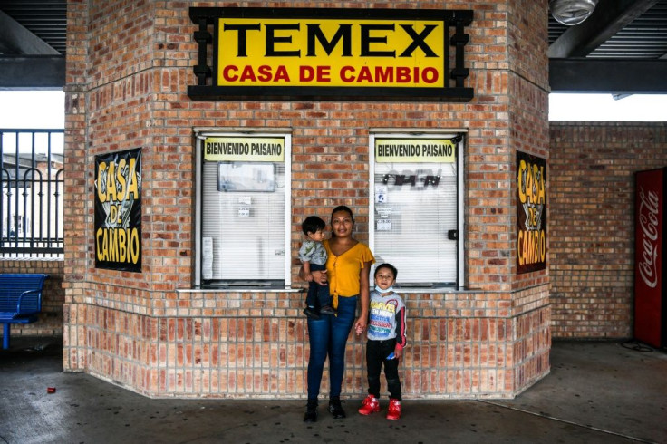 Amanda Garcia, a migrant form Guatemala, poses with her sons Lauro Garcia (5) and Wilson Garcia (10 months) as they wait for a bus near the Gateway International Bridge, between the cities of Brownsville, Texas, and Matamoros, Mexico March 16, 2021