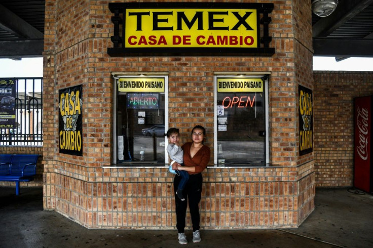 Eva Maria Polanco (25), a migrant form Central America, poses with her daugther Helen Salguero (2) as they wait for a bus near the Gateway International Bridge, between the cities of Brownsville, Texas, and Matamoro, Mexico on March 15, 2021