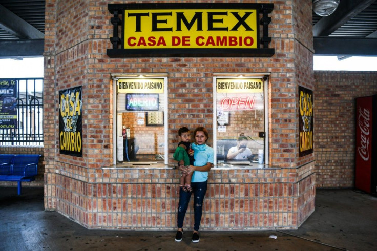 Luvia Tabora (25) A migrant form Central America poses with her son Dilan Tabora (1) as they wait for a bus at a station near the Gateway International Bridge, between the cities of Brownsville, Texas, and Matamoros, Mexico on March 14, 2021
