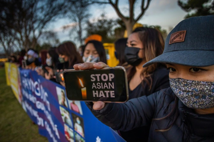 Julie Tran holds her phone during a candlelight vigil in California on March 17, 2021 to unite against violence targeting Asians  after a shooting left eight people dead in Atlanta, Georgia, including at least six Asian women