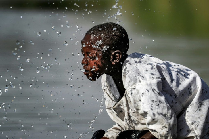 A boy splashes himself with water in a river in Sudan's Fashaqa region, a region claimed by both Sudan and Ethiopia