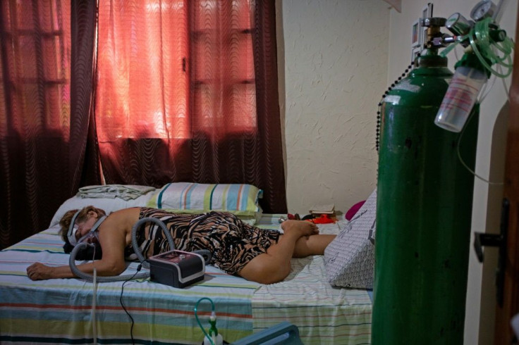 Dilza Maria Pereira Rodrigues, 71, is seen during a physiotherapy session as she recuperates at home after spending 15 days at hospital with Covid-19