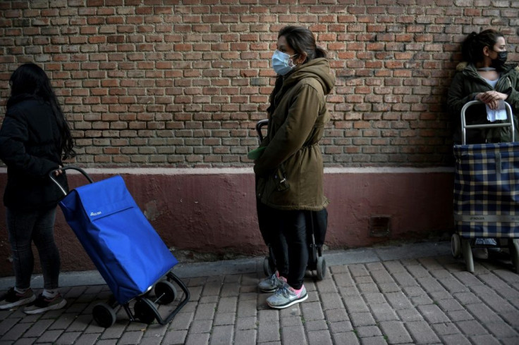 Mother-of-two Reina Chambi waiting outside a soup kitchen in the freezing wind in the Vallecas district