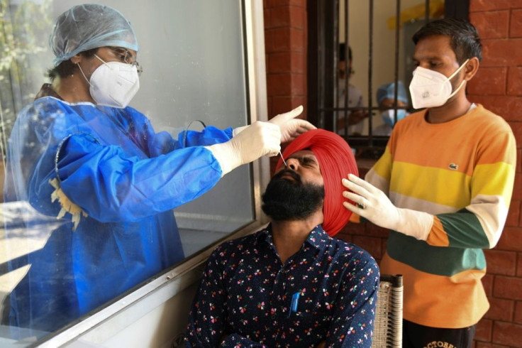 A health worker collects a sample from a man in Amritsar, India to test for coronavirus. Indian drugmaker Stelis Biopharma now has a deal to produce 200 million doses of the Russian Sputnik V vaccine.