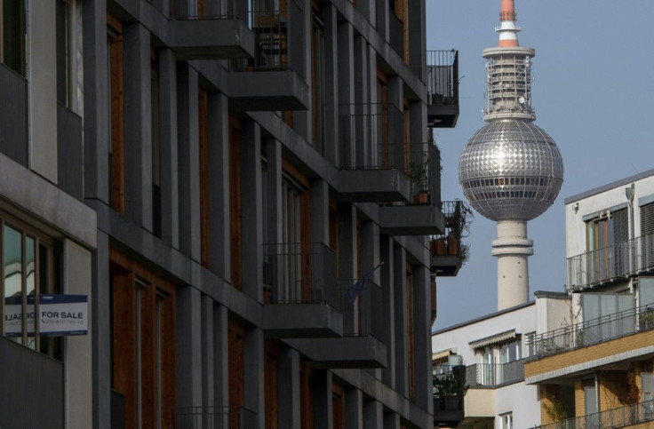 Berlin's world-famous TV tower looms over a block of flats with a 'for sale' sign