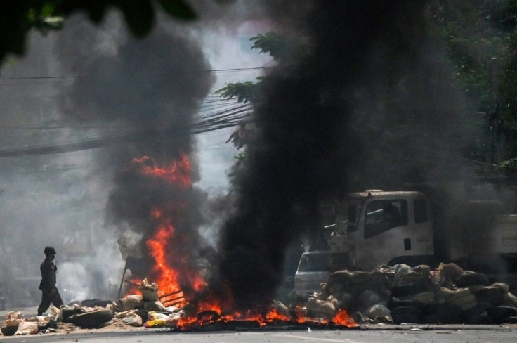 Soldiers set fire to barricades erected by protesters in Yangon