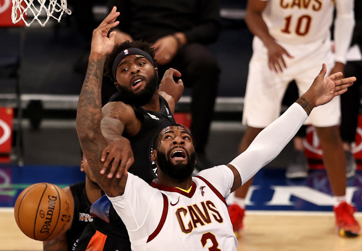Andre Drummond #3 of the Cleveland Cavaliers is fouled as he has for the net by Mitchell Robinson #23 of the New York Knicks