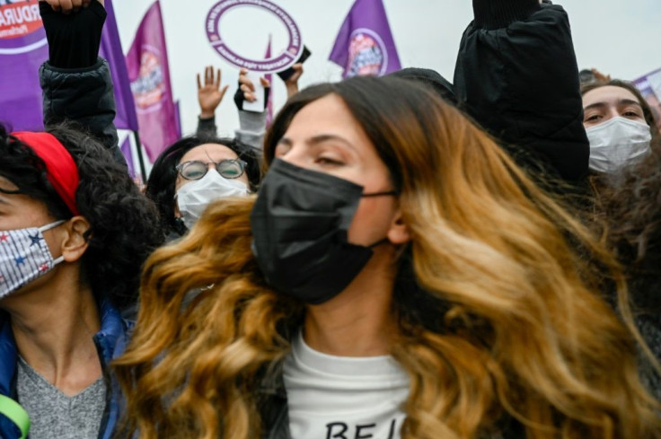 Protester holds flags reading "We will stop femicides" during a demonstration against Turkey's withdrawal from Istanbul Convention, in Istanbul, on March 20, 2021