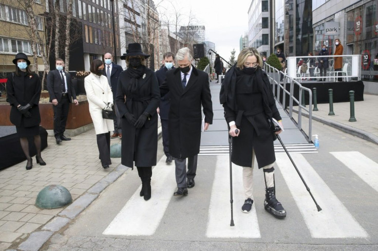 Brussels Airport suicide attack survivor Karen Northshield walks with King Philippe and Queen Mathilde at a ceremony to commemorate the worst massacre in Belgium's modern peacetime history