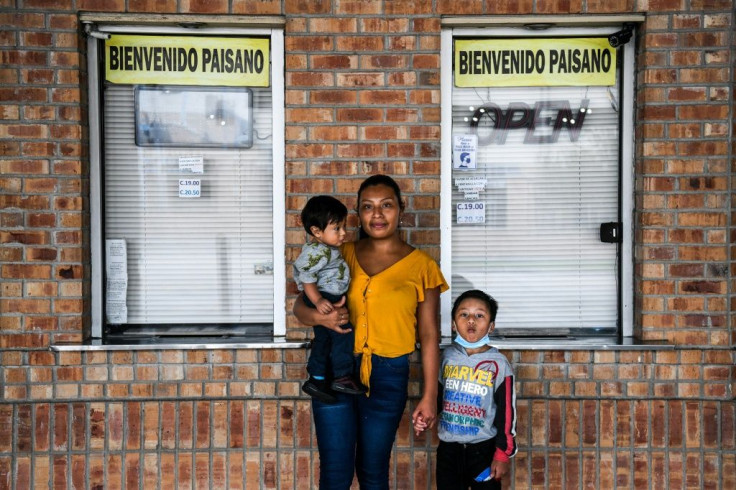 Amanda Garcia, a 23-year-old migrant from Guatemala, stands with her young sons at a bus station near Brownsville, Texas