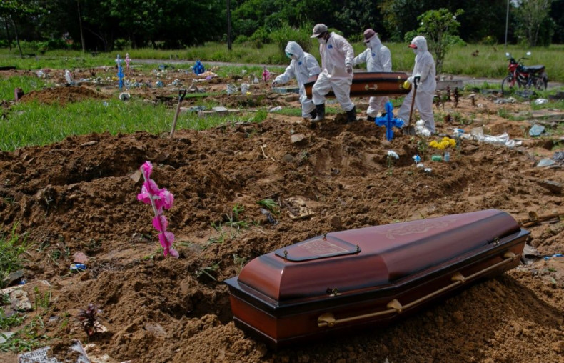 Workers in protective gear carry the coffin of a COVID-19 victim at the Parque Tapana public cemetery in Belem, Para state, in northeastern Brazil