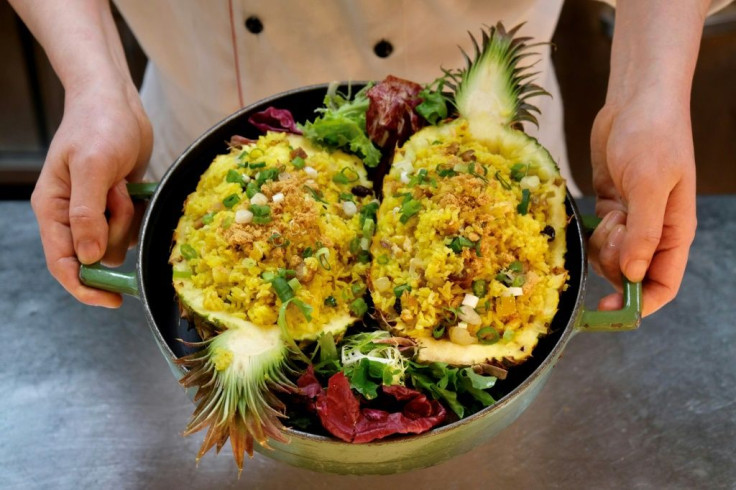 A restaurant employee holding a dish of pineapple fried rice at the Courtyard by Marriott hotel in Taipei