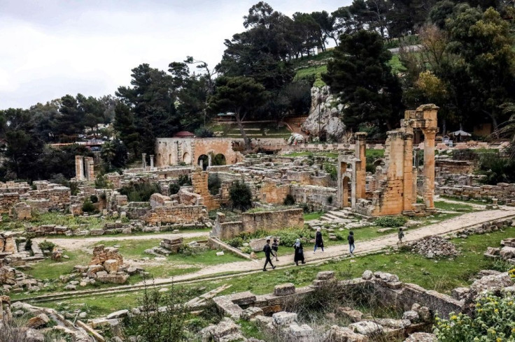 People walk through the remains of the Sanctuary of Apollo in the UNESCO-listed ruins of the ancient city of Cyrene in eastern Libya