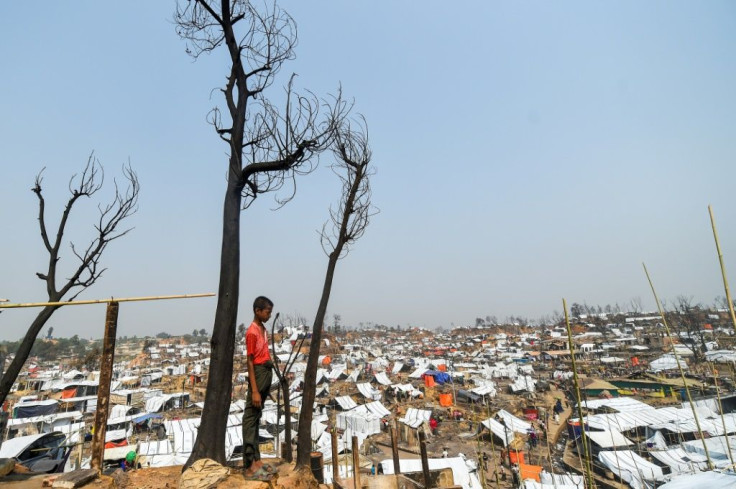A Rohingya refugee child stands by his burnt home days after a fire at a refugee camp in Bangladesh's southeastern Cox's Bazar district